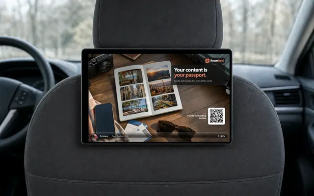 Straight, front-facing RoamReel tablet installed flush against a passenger headrest with its strap mount concealed, playing a travel-creator campaign